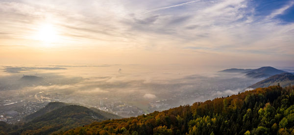 Aerial shoot of graz city covered if fog on autumn morning during sunraise. view from plaubutsch