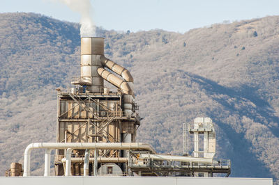 Low angle view of factory against mountain