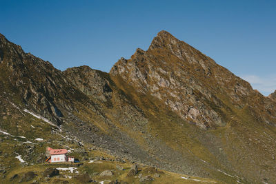 Low angle view of rocky mountains against clear sky