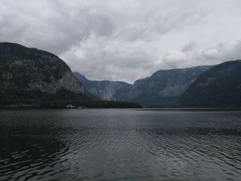 Scenic view of lake by mountains against sky