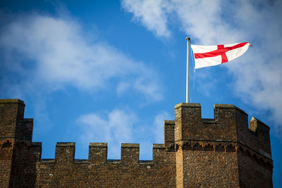 Low angle view of flags on building against sky