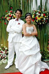 Portrait of bride and bridegroom with arms crossed standing