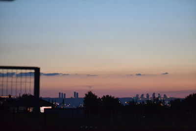 High angle view of silhouette buildings against sky at sunset