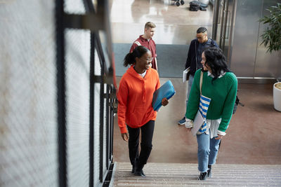 High angle view of students talking while moving on steps at university