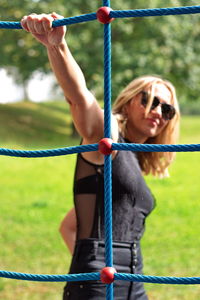 Portrait of woman holding rope in park