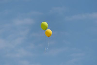 Low angle view of balloons against sky