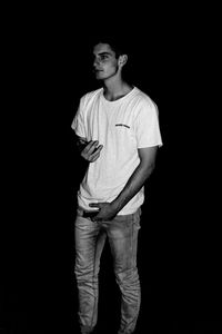 Man standing against black background