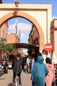 Rear view of people riding bicycle on street