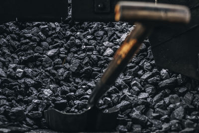 Close-up of spade amidst coal