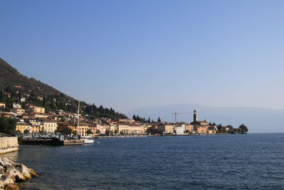 Scenic view of sea by buildings against clear sky