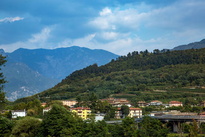 Scenic view of townscape by mountains against sky