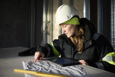 Female engineer checking plans on digital tablet