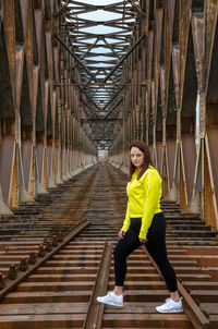 Portrait of young woman exercises on railway