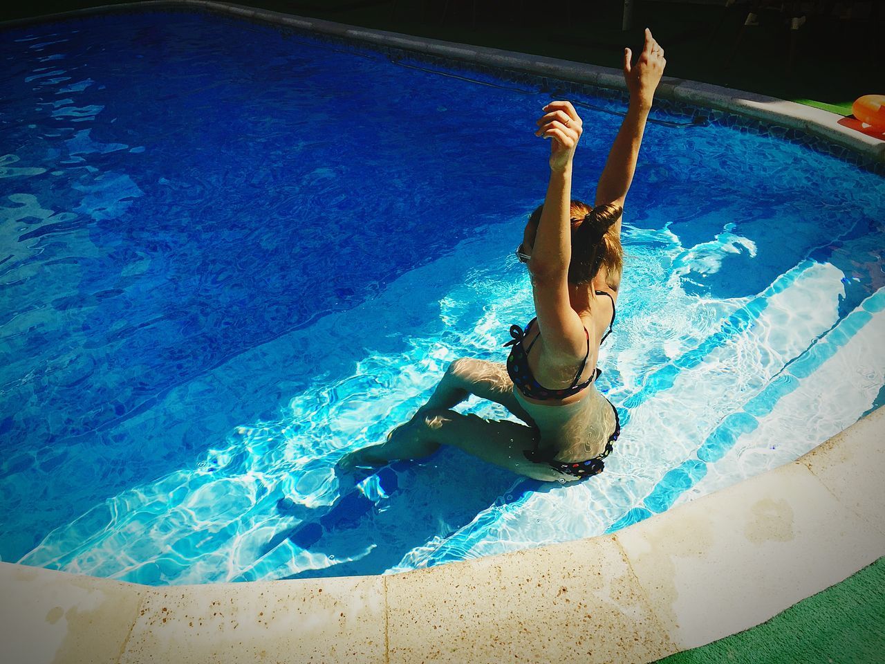 YOUNG WOMAN SWIMMING IN POOL WITH WATER