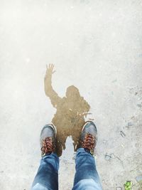 Low section of a man with reflection in puddle