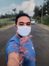 Portrait of young man standing on road