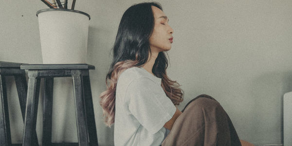 Side view of young woman looking away at home