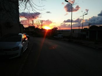 Car on street against sky during sunset