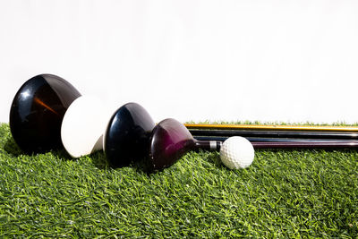 Close-up of golf ball on grass against white background