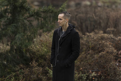 Young man looking away in forest