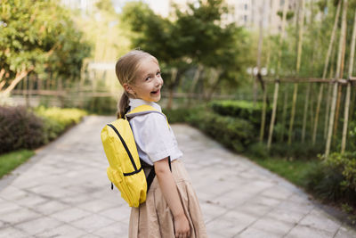 Side view of a girl looking away on footpath