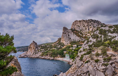 Scenic view of sea and mountains against sky