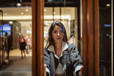 Portrait of young woman seen through glass