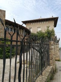 Old house by building against sky