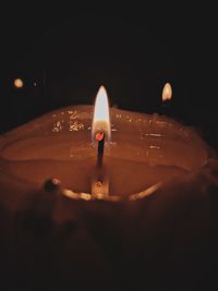 Close-up of lit candle in water at night