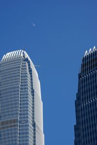 Low angle view of skyscrapers against clear blue sky