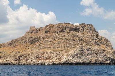 Rock formations by sea against sky