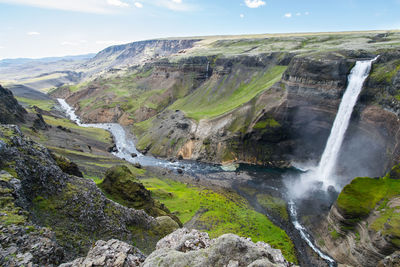 Scenic view of waterfall against sky