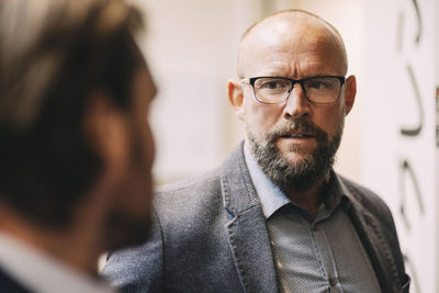 Close-up of businessman discussing with colleague at office