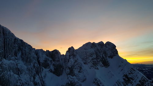 Scenic view of snowcapped mountains against sky during sunset