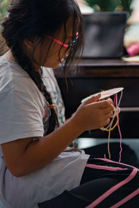 Rear view of girl crafting at home