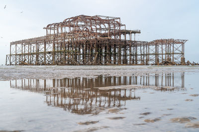 Damaged pier on sea against sky