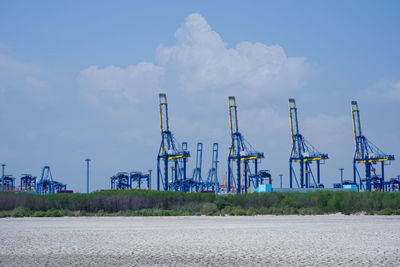 Cranes against sky in factory