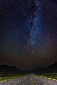 Scenic view of landscape against star field at night