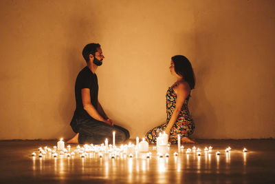 Full length of woman standing against illuminated wall