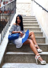 Portrait of woman sitting on staircase