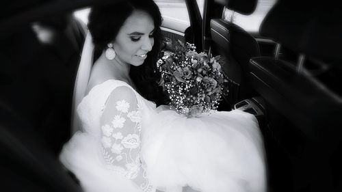 Bride with bouquet in car