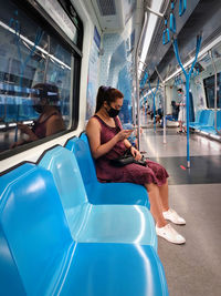 Woman sitting on seat in bus