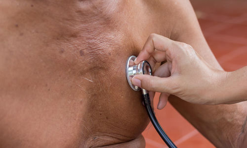 Cropped hand of doctor examining patient in hospital