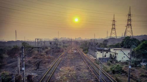 Railroad tracks against sky during sunset