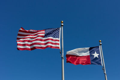 Low angle view of flag flags against blue sky