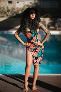 Portrait of young woman standing in swimming pool