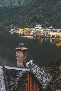 Scenic view of lake by buildings against mountain