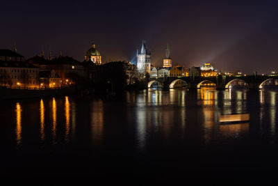 Scenic view of illuminated prague skyline at night. charles bridge across vltava river 