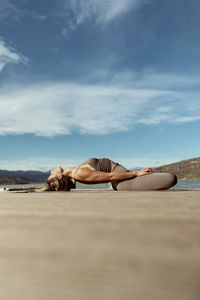 Sportswoman doing matsyasana on jetty