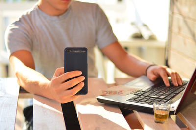 Midsection of man using mobile phone